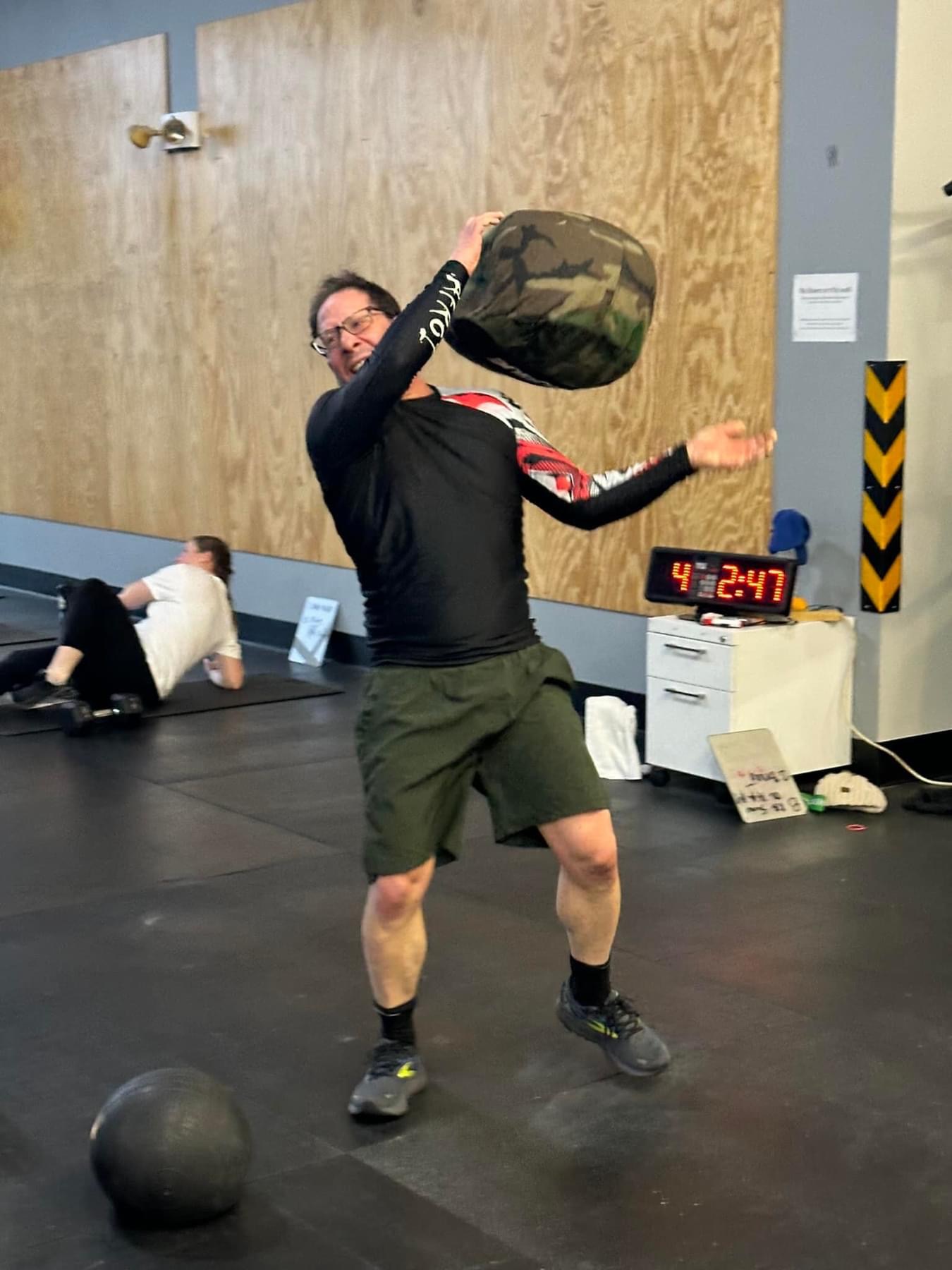 Mark Shalinsky lifting a sandbag during a CrossFit workout